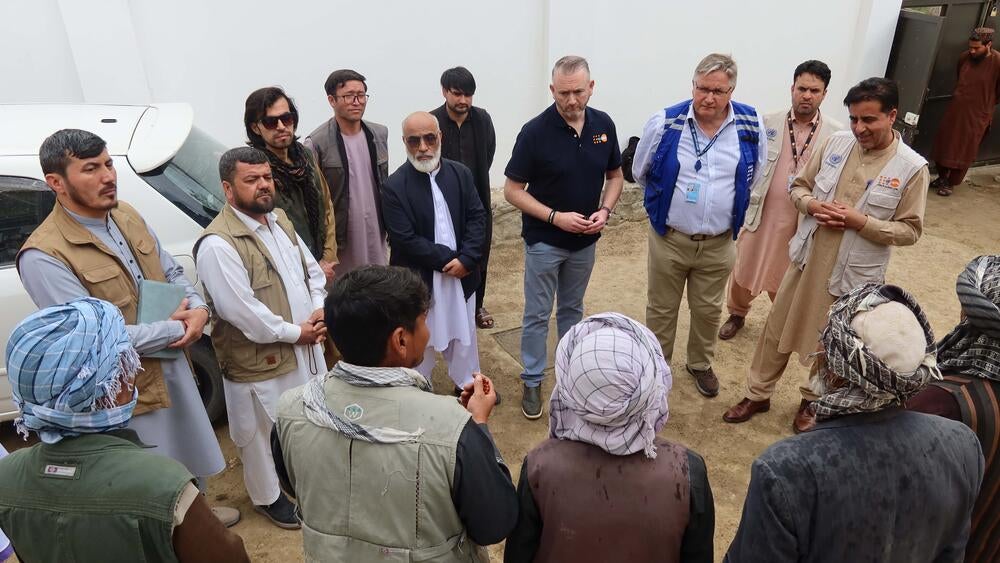 A group of men standing up while having a discussion.