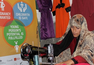 Farzana making a dress with a sewing machine