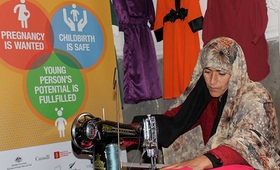 Farzana making a dress with a sewing machine