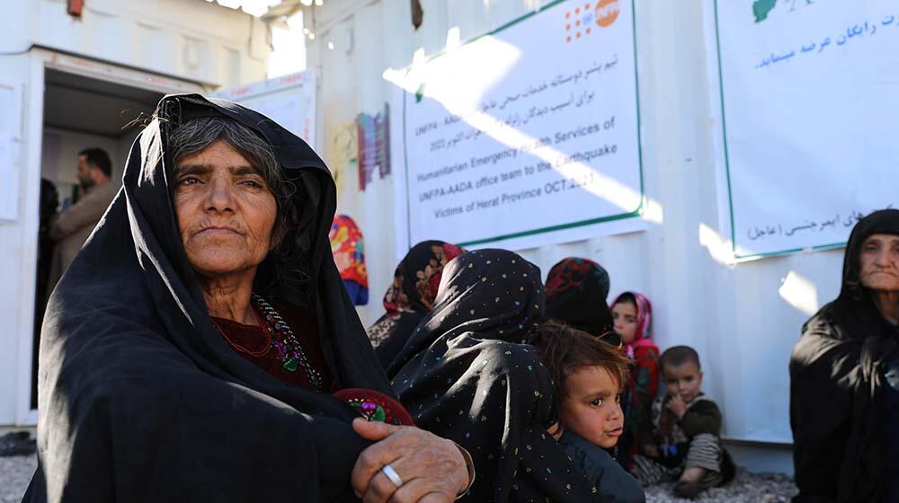 Women and children sitting outside a clinic.