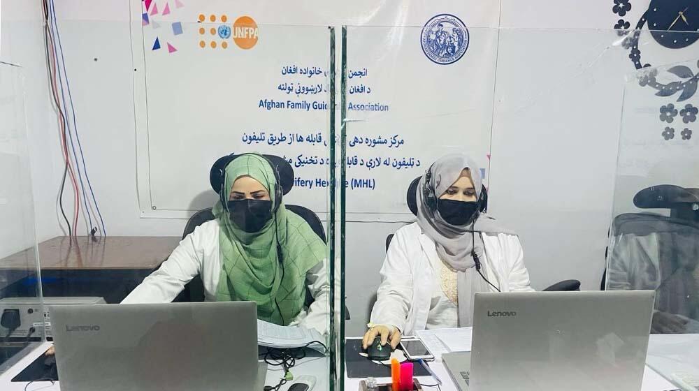 Two female health workers wearing hijab working in front of computers