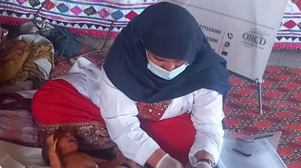 A midwife cleans up a newborn baby after delivery