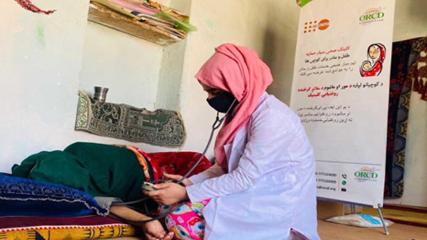 A midwife attending to a woman lying on the floor.
