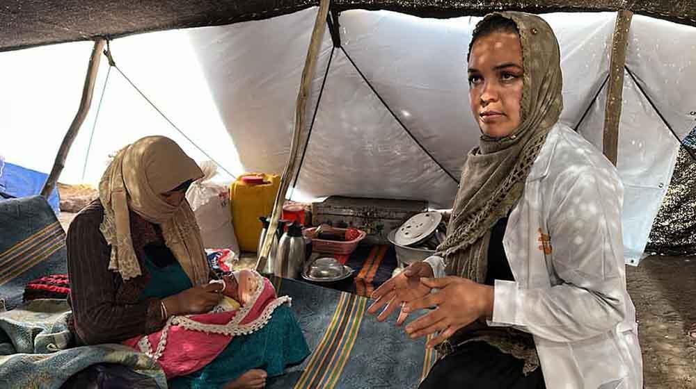 A midwife with a mother and newborn inside a tent being used as temporary recovery room at the maternity hospital in Herat City.